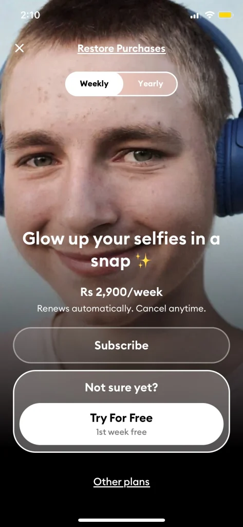 Remini app subscription screen showing options for a weekly plan costing Rs 2,900 per week. The screen displays a message 'Glow up your selfies in a snap' with a close-up image of a man smiling. The screen offers subscription options, including a 'Try For Free' button for a 1-week free trial.